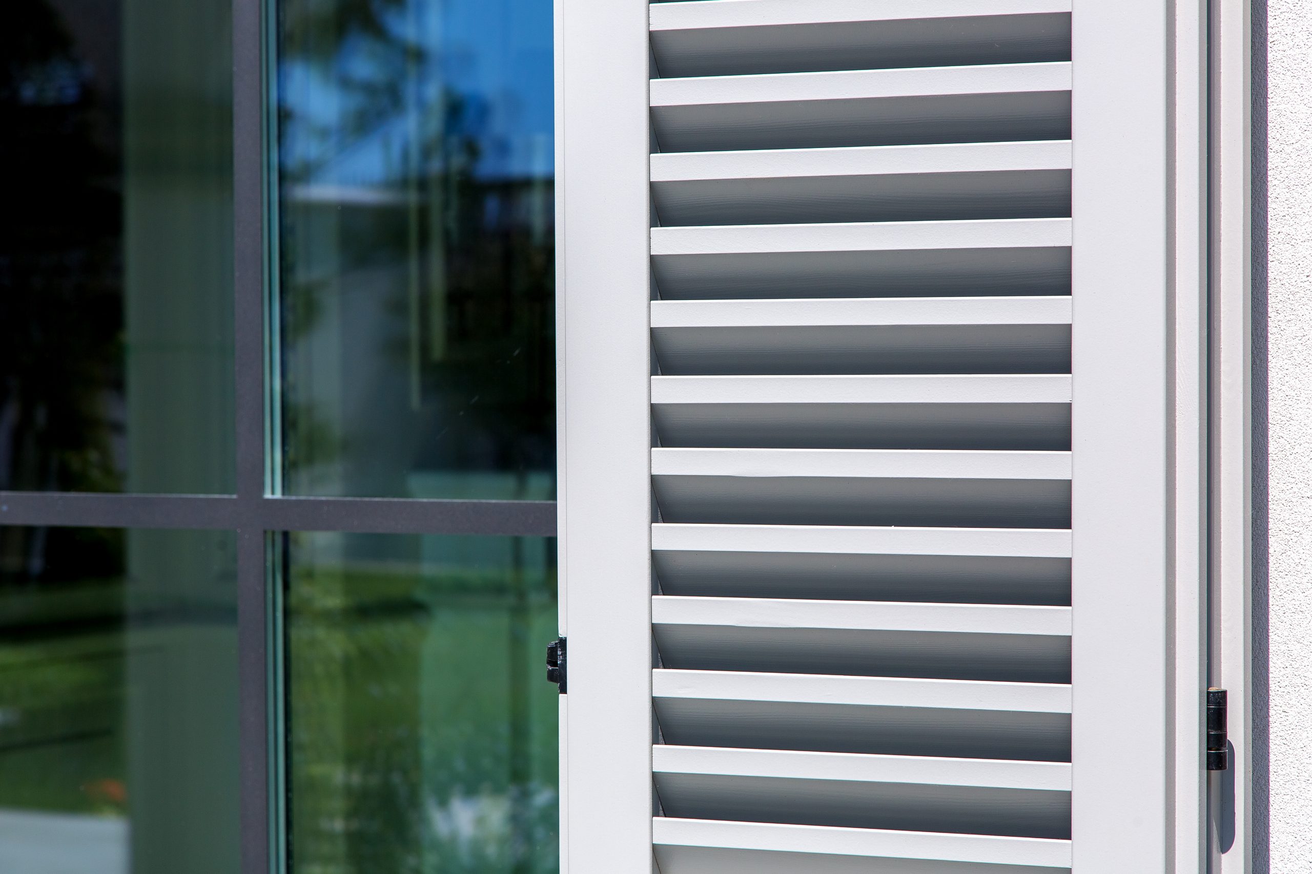 woo­den shutters of gray color, clo­se up of the exte­rior of the hou­se in the Ita­li­an style.